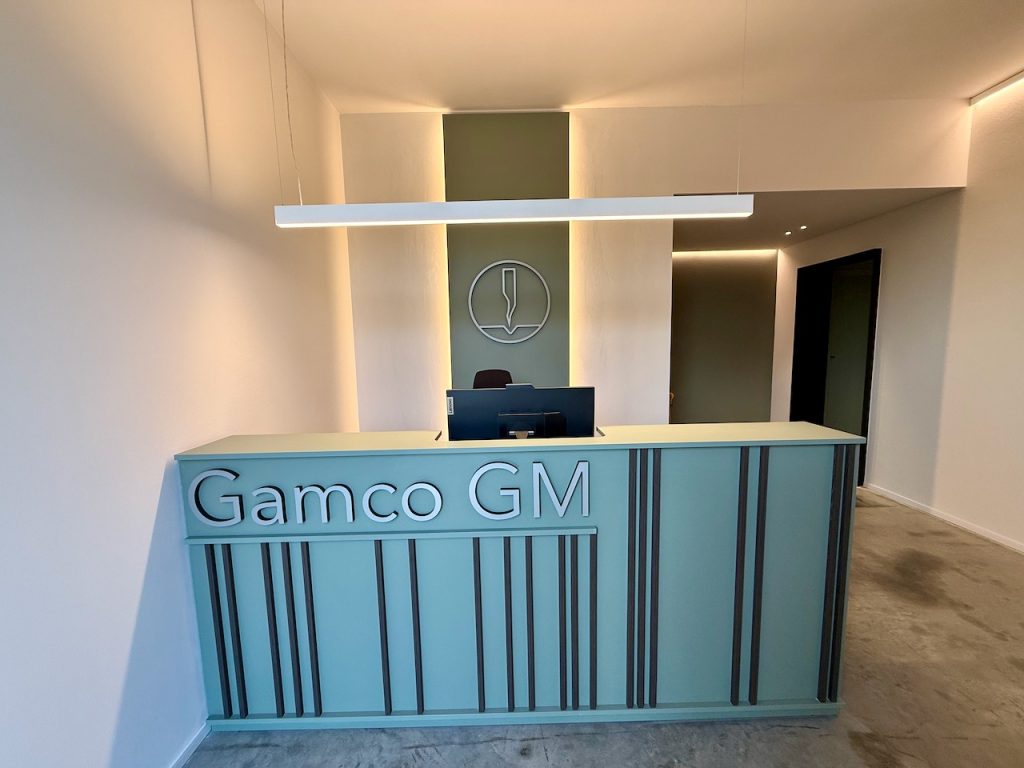 Reception frontale: bancone a lamelle e lettere a rilievo
