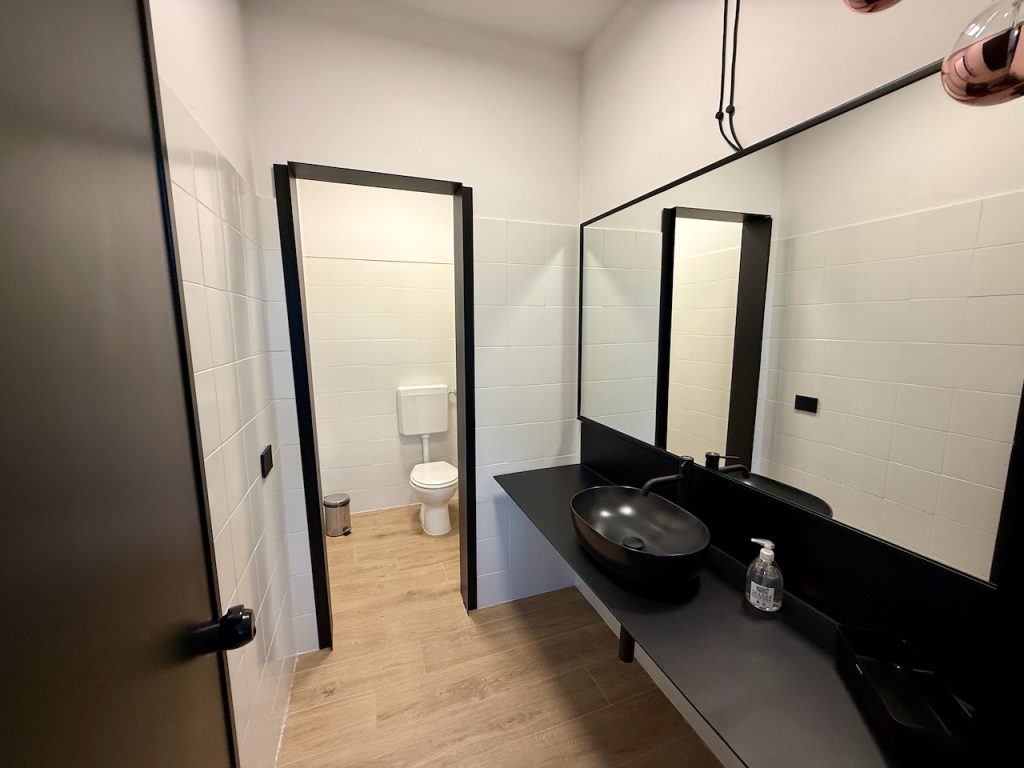 Servizio igienico: lavabo nero, specchio con cornice