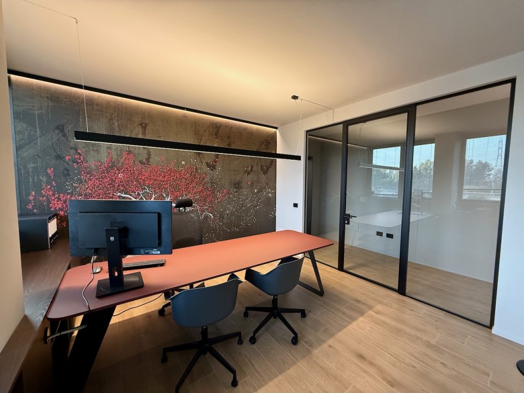 Ufficio con scrivania terracotta e parete con ciliegio